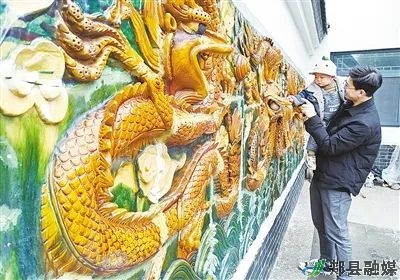 赵雁冰带着孩子在琉璃五龙壁前玩耍赵志鸿在教女儿