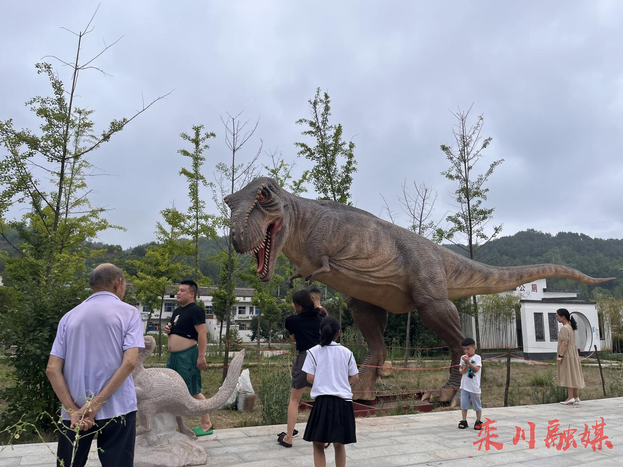 两座恐龙雕塑,分别为长13米的栾川霸王龙模型和高1米多的秋扒龙模型